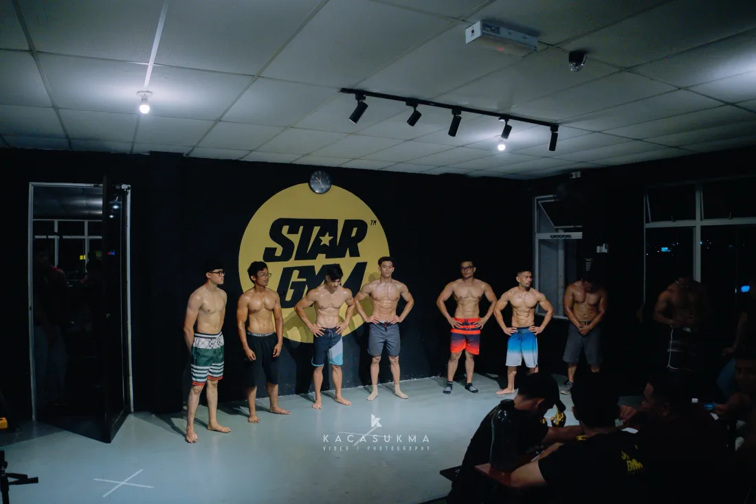 Line of athletes posing on stage at a bodybuilding competition