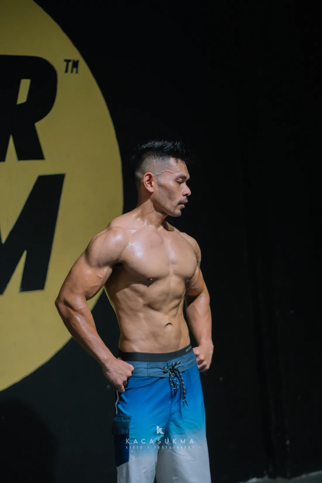 Competitor performing a side chest pose on stage